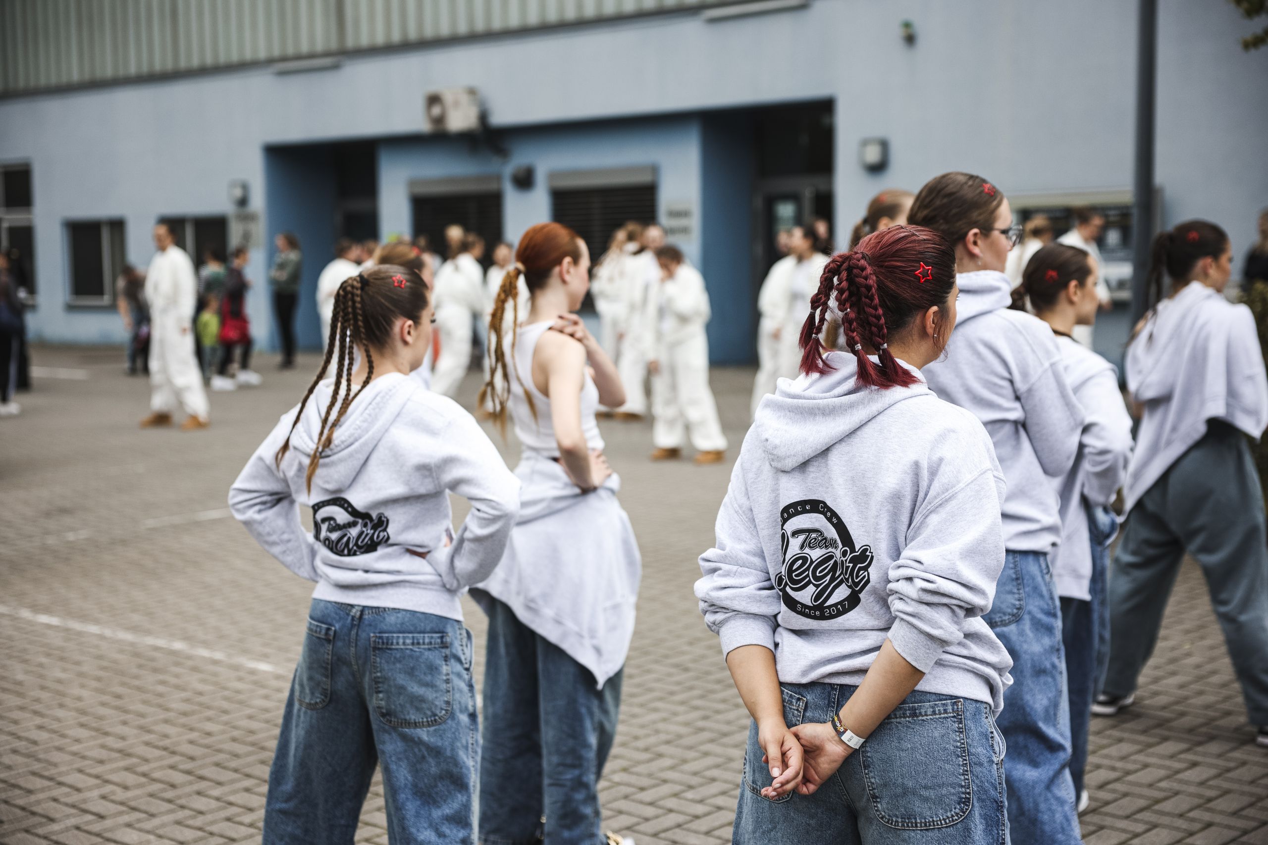 Teammitglieder in Team-Legit-Hoodies vor einer Veranstaltungshalle