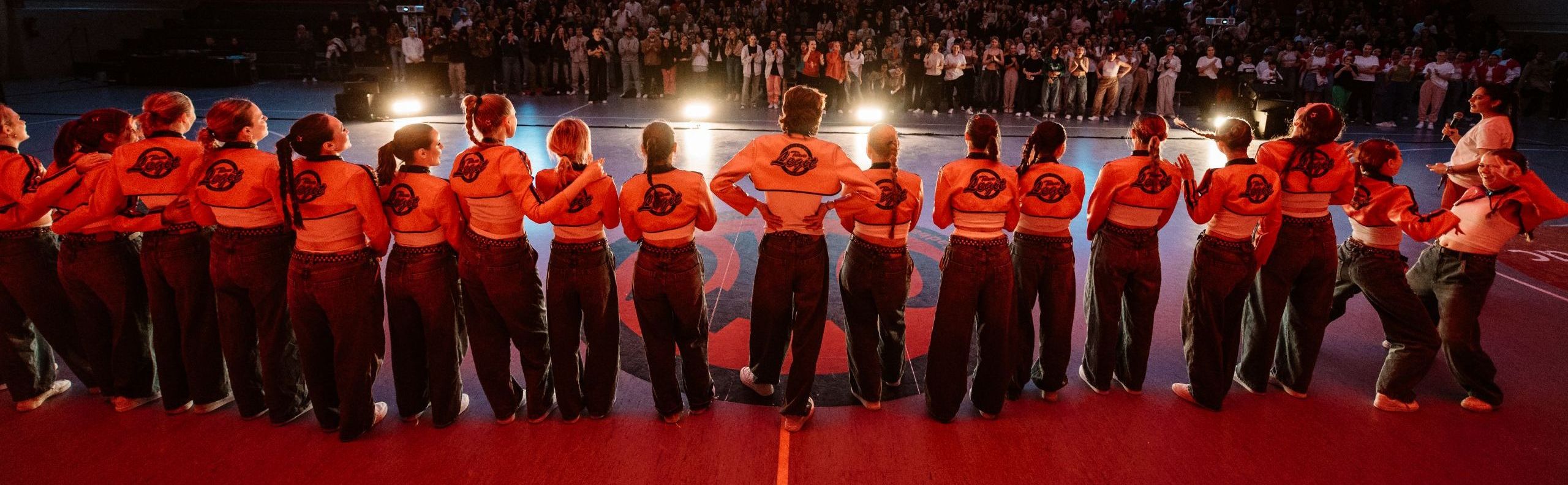Tanzcrew blickt gemeinsam von der Bühne ins Publikum